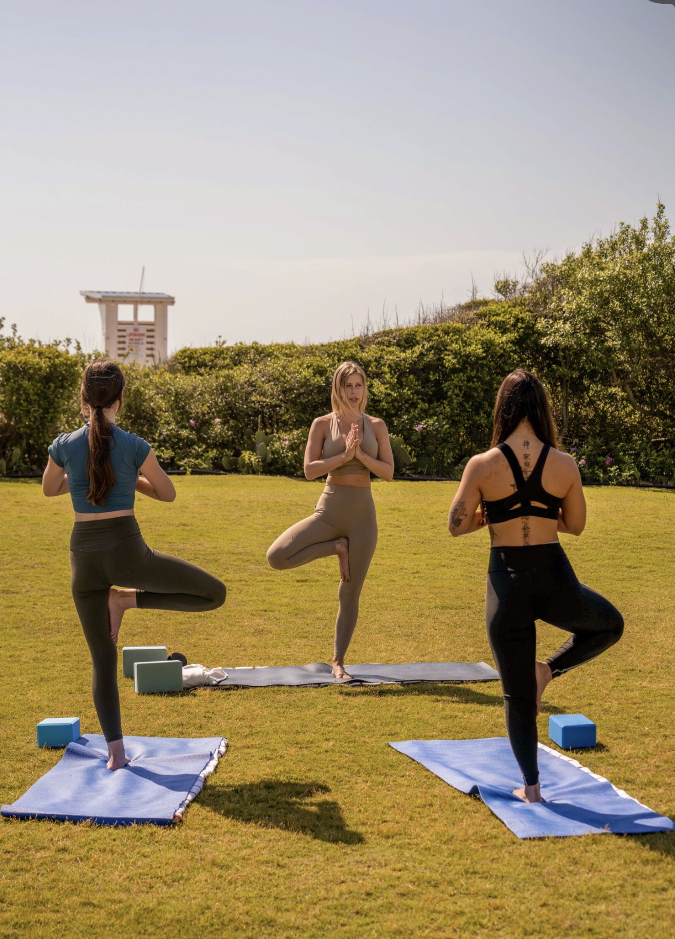 Women practicing tree pose outdoors during a breathwork session
