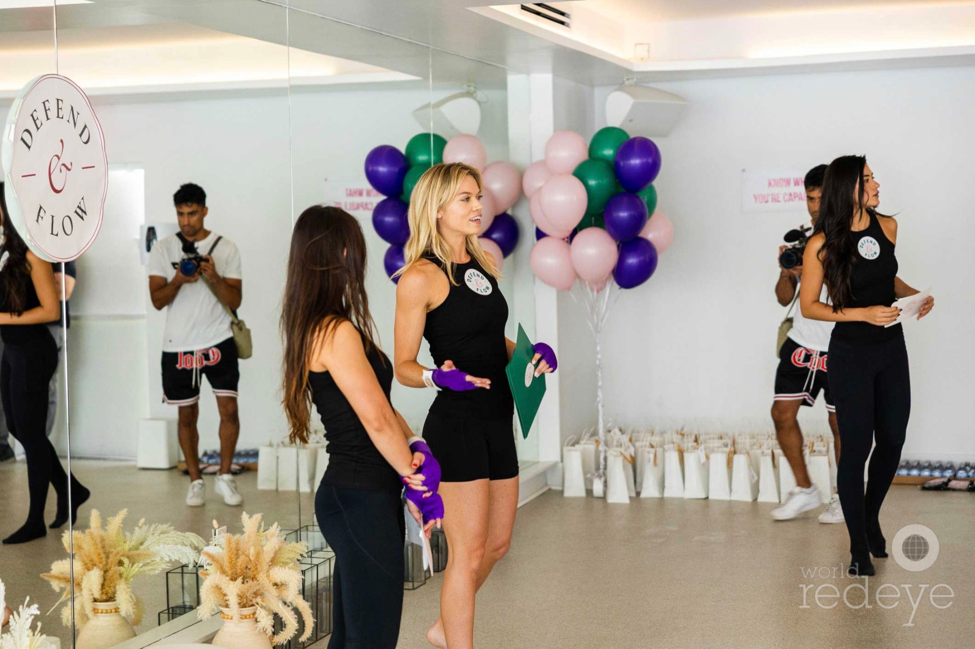 The Defend & Flow team welcomes attendees beside balloons and gift bags.