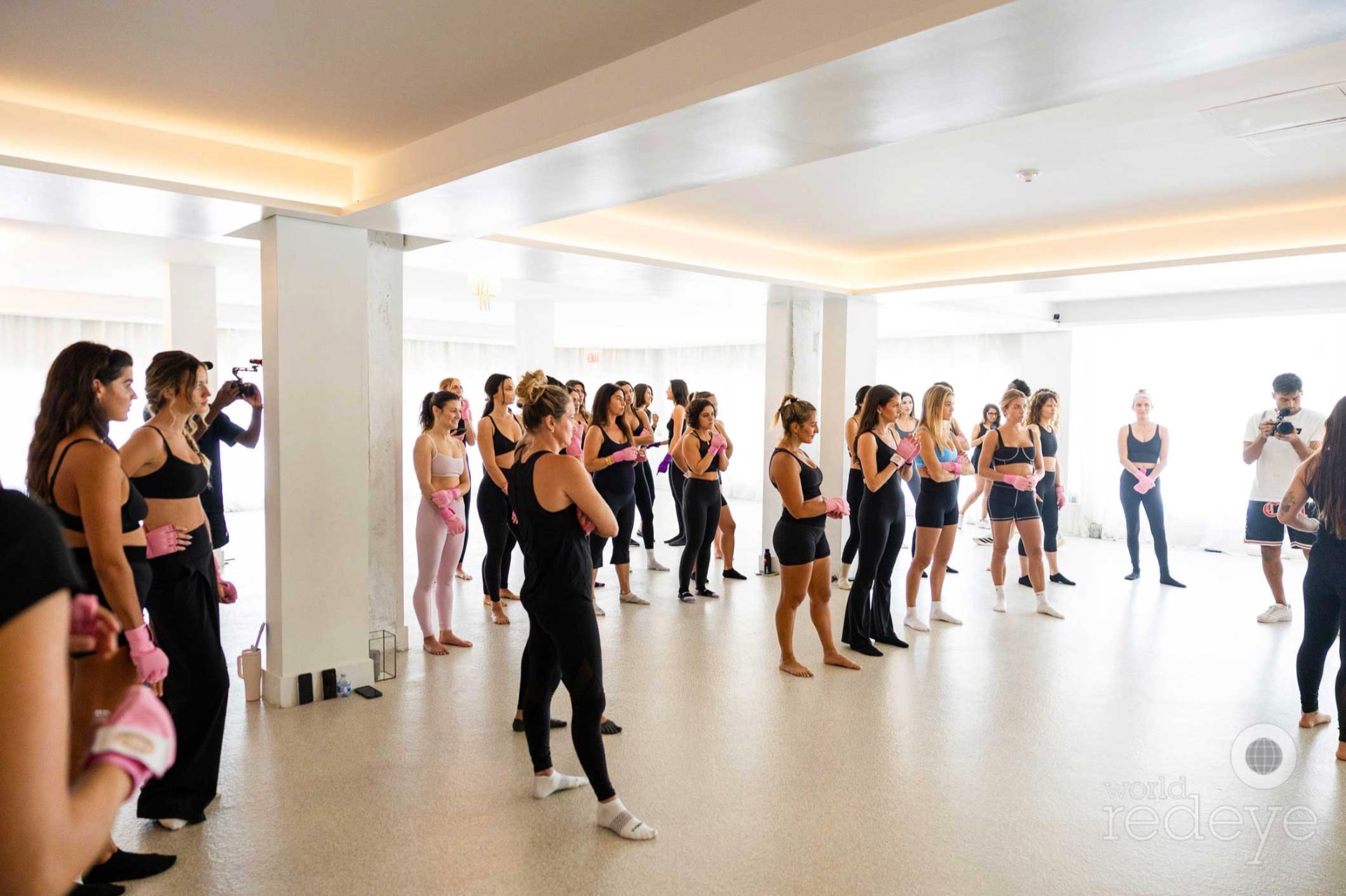 The group gathers in a wide circle in the bright Miami Beach studio.