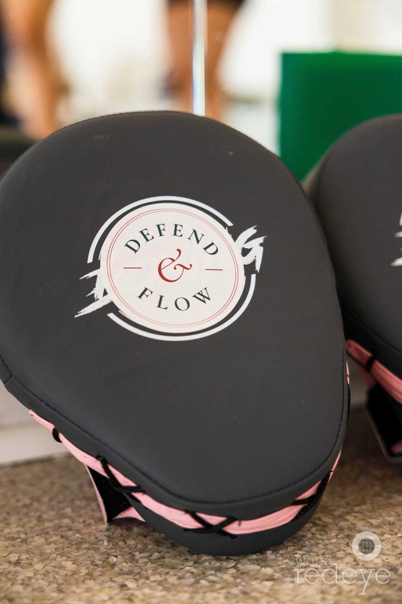 Close-up of a Defend & Flow branded focus mitt in black and pink.